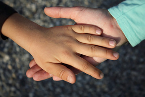 Kinderhand auf Hand von Erwachsenen Kinderhand auf Hand von Erwachsenen